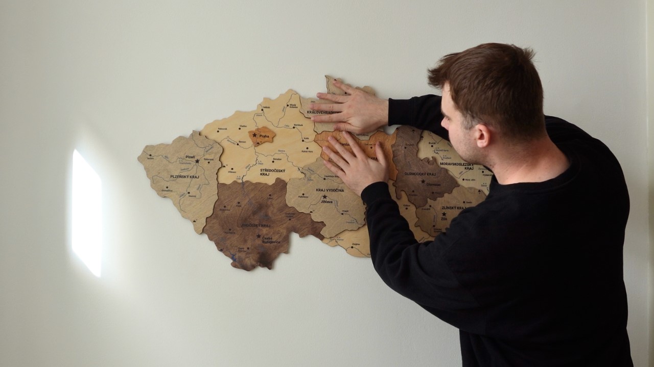 Detail dřevěné mapy České republiky s nalepenými krajskými znaky